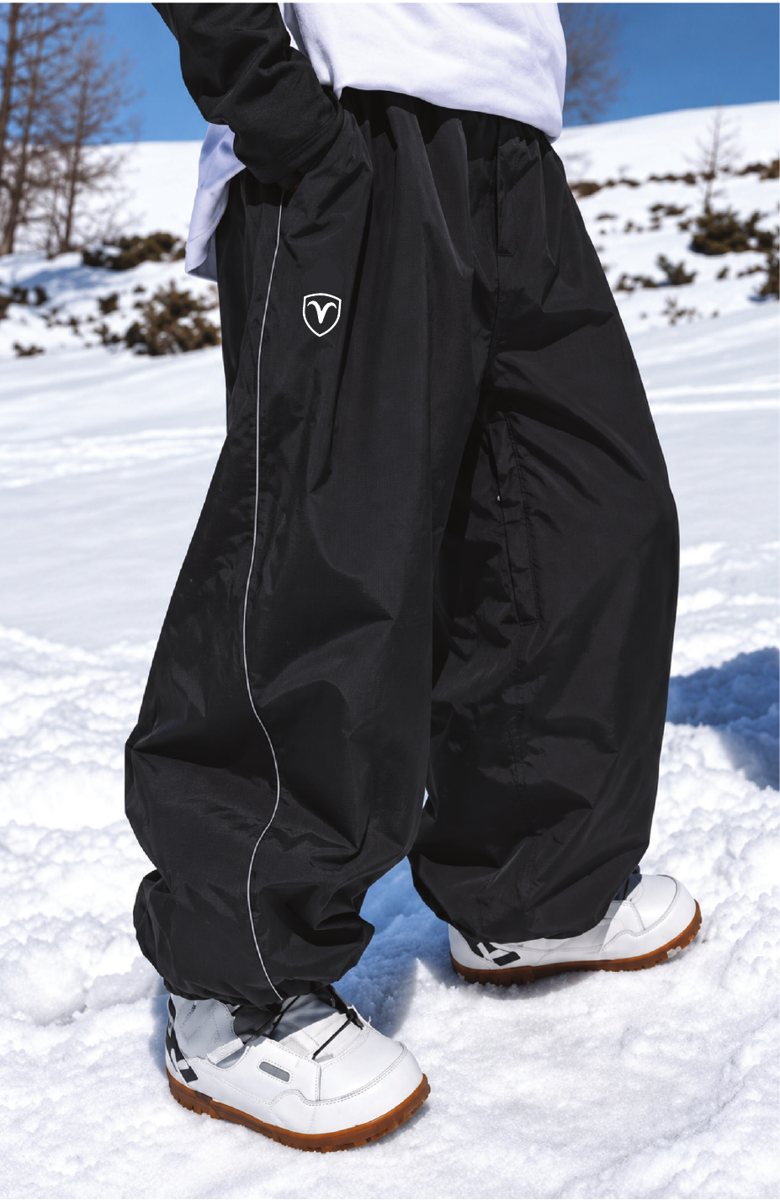 Hodgeline baggy black snow pants with an elastic cuff, worn in the snow